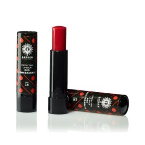 Δύο σωληνάρια Garden Protecting Lip Balm Red Pomegranate SPF15 5,2 g, με μαύρη και κόκκινη συσκευασία, με ένα σωληνάριο ανοιχτό για εμφάνιση του προϊόντος μέσα.