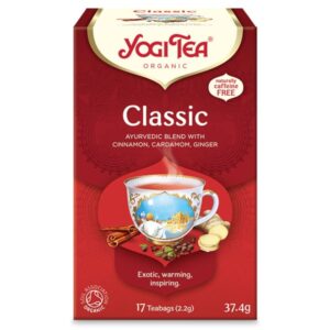 Ένα κουτί Yogi Tea Classic 37,4 g, με αρωματική κανέλα, κάρδαμο και τζίντζερ, διακοσμημένο με εικονογράφηση φλιτζάνι τσαγιού και λεπτομερή ετικέτα.