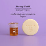 Apivita Solid Foamy Cleanser Face & Eyes 80 g Ένα ποτήρι με μέλι και ένα Apivita Solid Foamy Cleanser Face & Eyes 80g βρίσκονται σε μοβ φόντο, με ελληνικό κείμενο από πάνω τους.